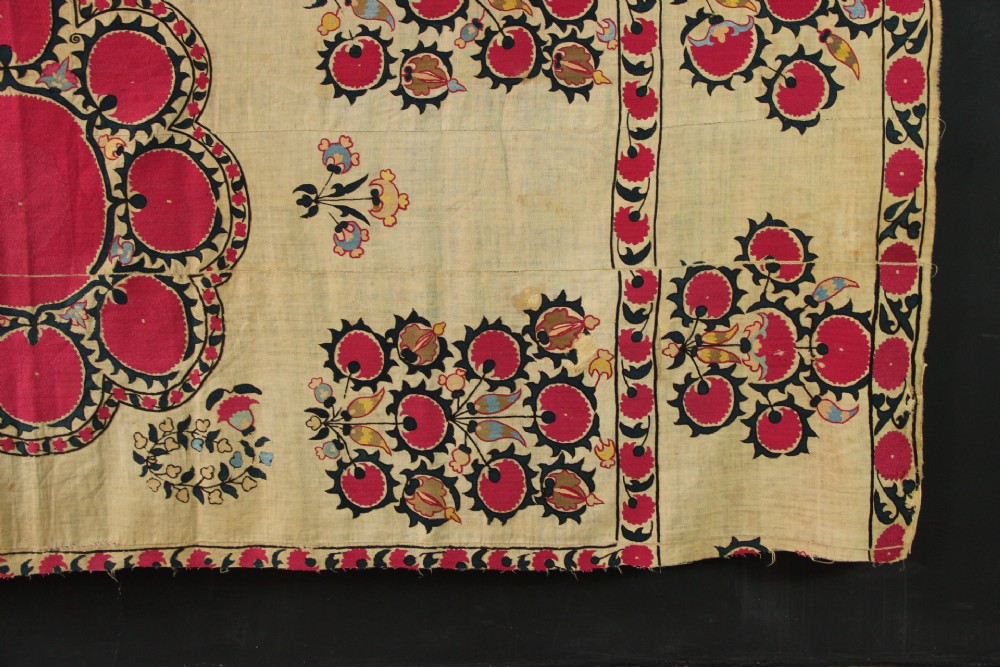 A rectangular hand-embroidered textile featuring central circular pomegranate motifs in crimson silk on a cream ground, framed by a floral border. View VIII