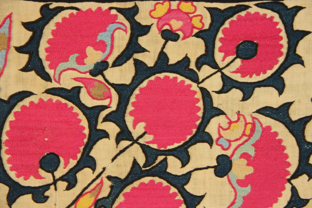 A rectangular hand-embroidered textile featuring central circular pomegranate motifs in crimson silk on a cream ground, framed by a floral border. View IX