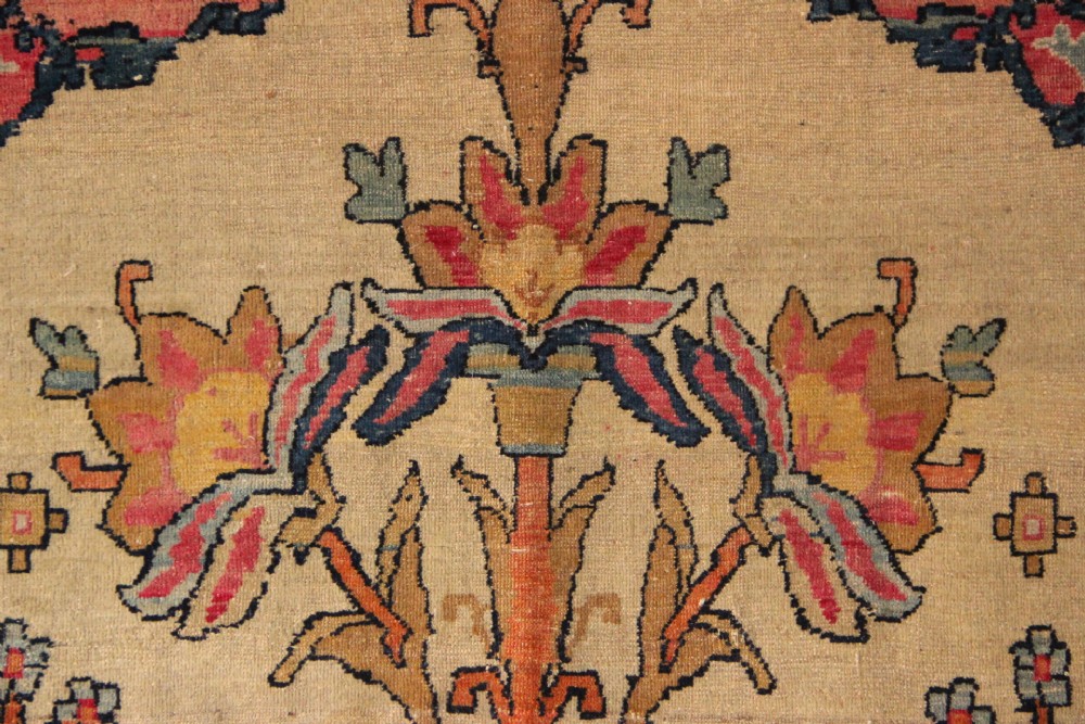 An antique hand-knotted Kirman Lavar wool rug featuring a central tree of life motif with birds and floral elements set on a cream field with a red border. View IV