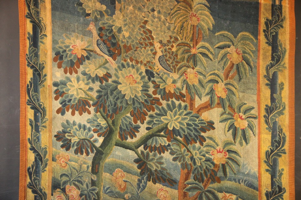 An 18th-century European needlework tapestry depicting lush botanical trees, perched birds, and floral motifs surrounded by a decorative foliate border. View II