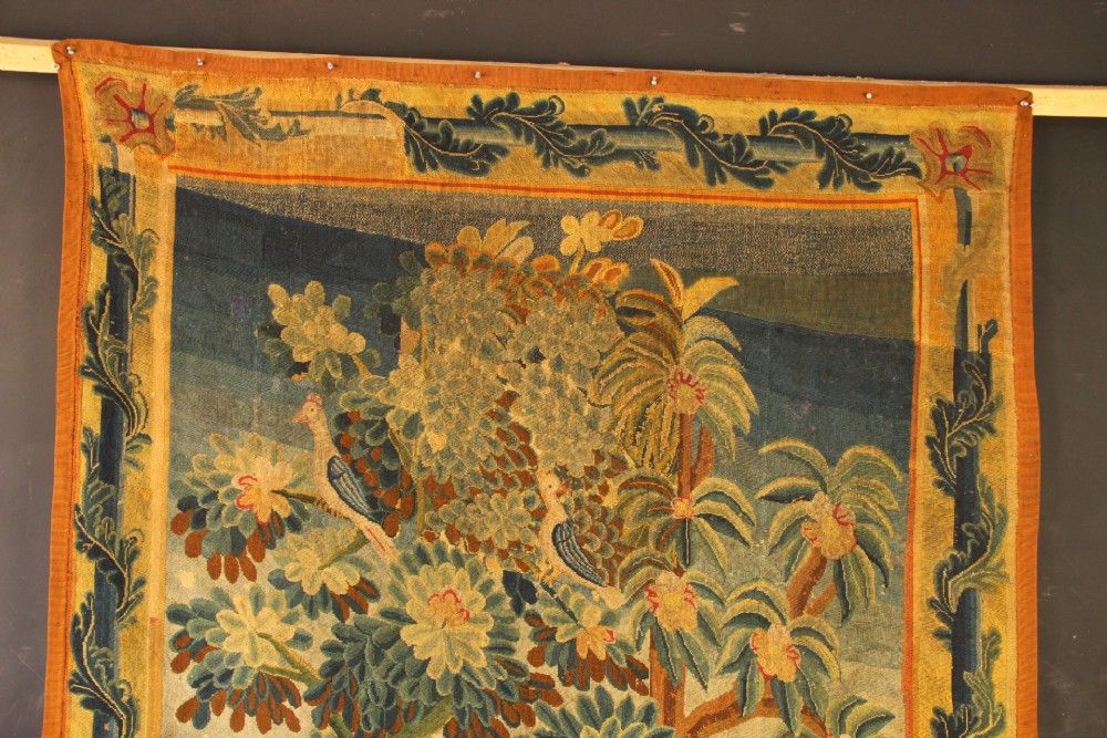 An 18th-century European needlework tapestry depicting lush botanical trees, perched birds, and floral motifs surrounded by a decorative foliate border. View IV