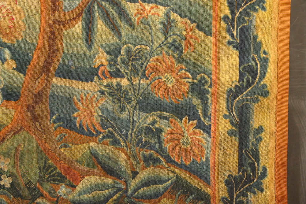 An 18th-century European needlework tapestry depicting lush botanical trees, perched birds, and floral motifs surrounded by a decorative foliate border. View XI