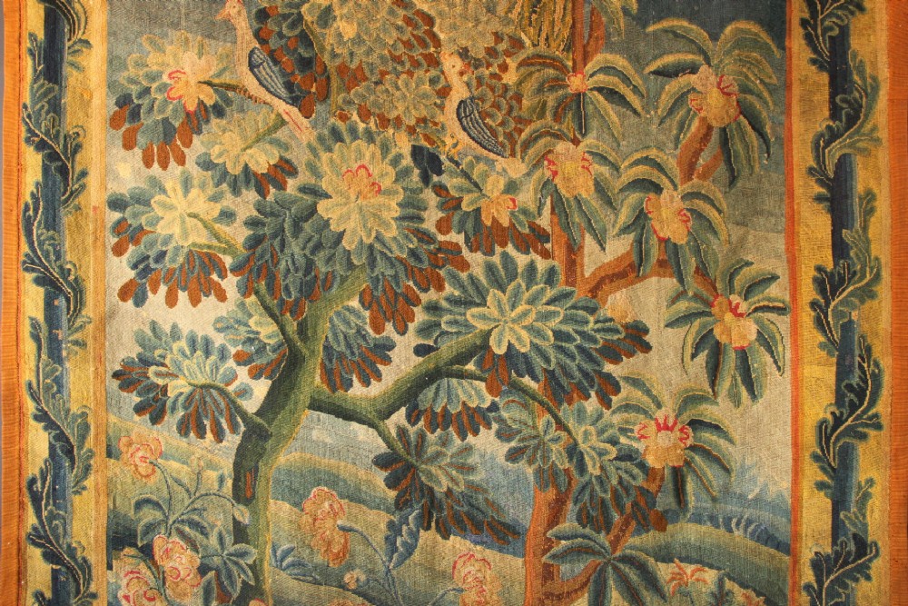An 18th-century European needlework tapestry depicting lush botanical trees, perched birds, and floral motifs surrounded by a decorative foliate border. View XIII