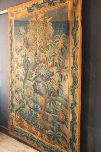 An 18th-century European needlework tapestry depicting lush botanical trees, perched birds, and floral motifs surrounded by a decorative foliate border. View XII