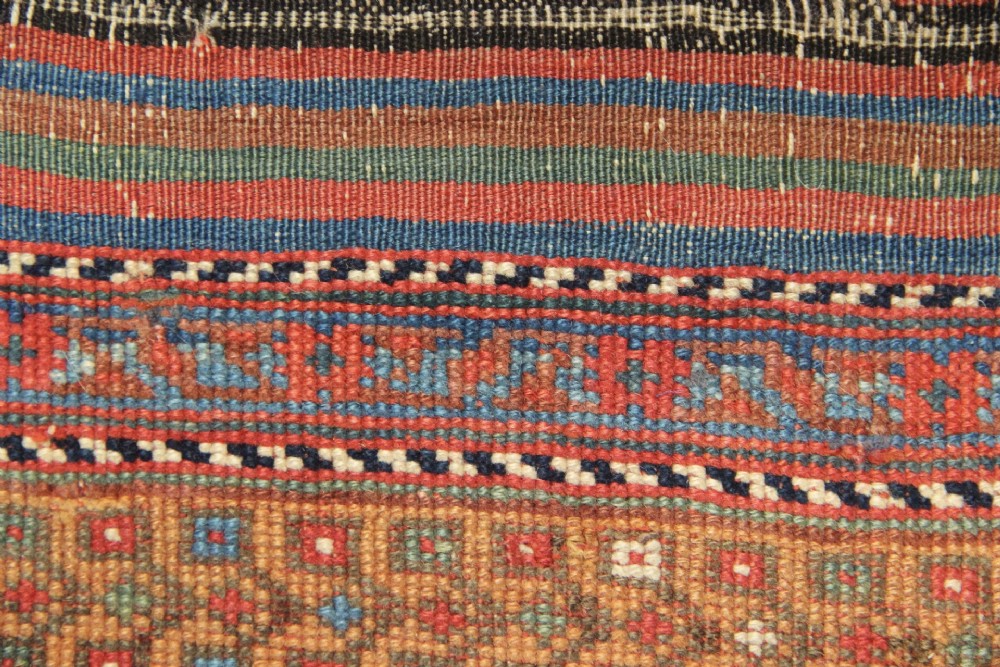 A hand-knotted rectangular wool carpet featuring a dark navy blue hexagonal field adorned with repeating geometric lattice motifs, surrounded by a bold terracotta red border. View XI