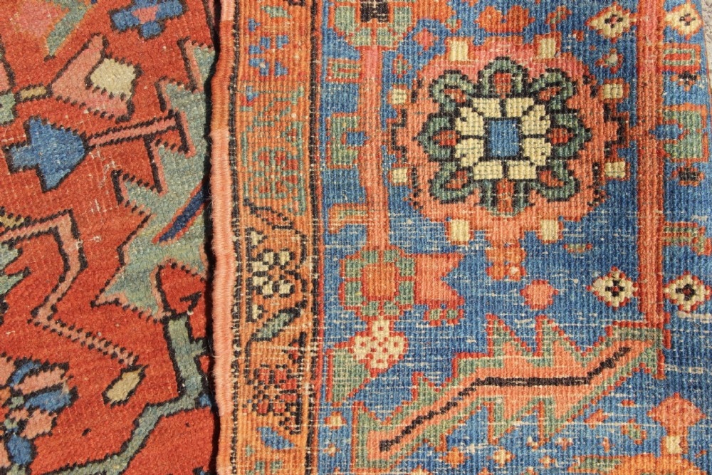 An antique hand-knotted Persian Bakshaish wool carpet featuring a central geometric motif on a terracotta red field framed by a wide blue floral border. View XIV