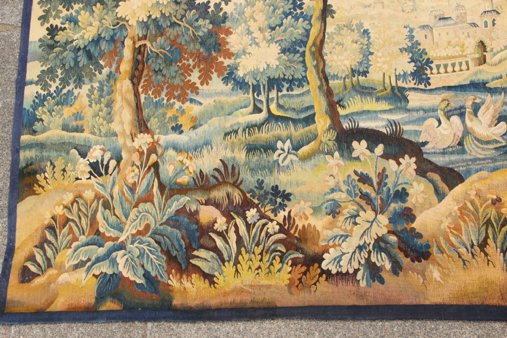 A large hand-woven French Aubusson verdure tapestry depicting swans swimming on a woodland river surrounded by trees and foliage. View IV