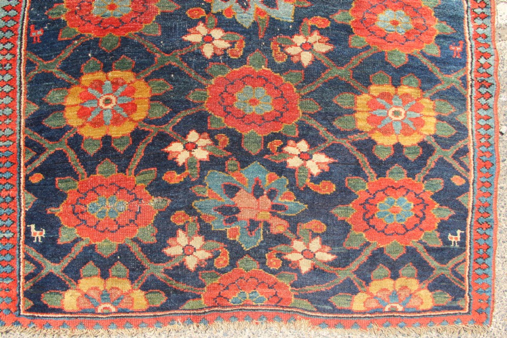 An extra-long hand-knotted antique Kurdish runner rug featuring a repeating Mina Khani floral lattice pattern in navy blue, rust red, and mustard yellow. View IV
