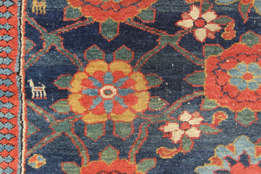 An extra-long hand-knotted antique Kurdish runner rug featuring a repeating Mina Khani floral lattice pattern in navy blue, rust red, and mustard yellow. View V