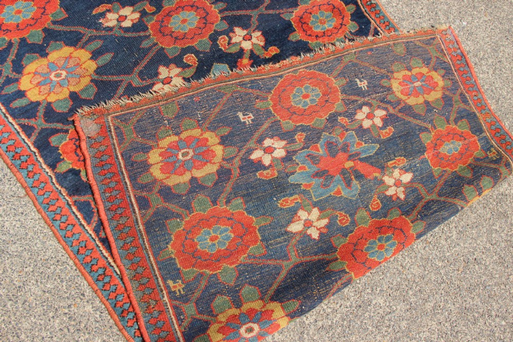 An extra-long hand-knotted antique Kurdish runner rug featuring a repeating Mina Khani floral lattice pattern in navy blue, rust red, and mustard yellow. View IX