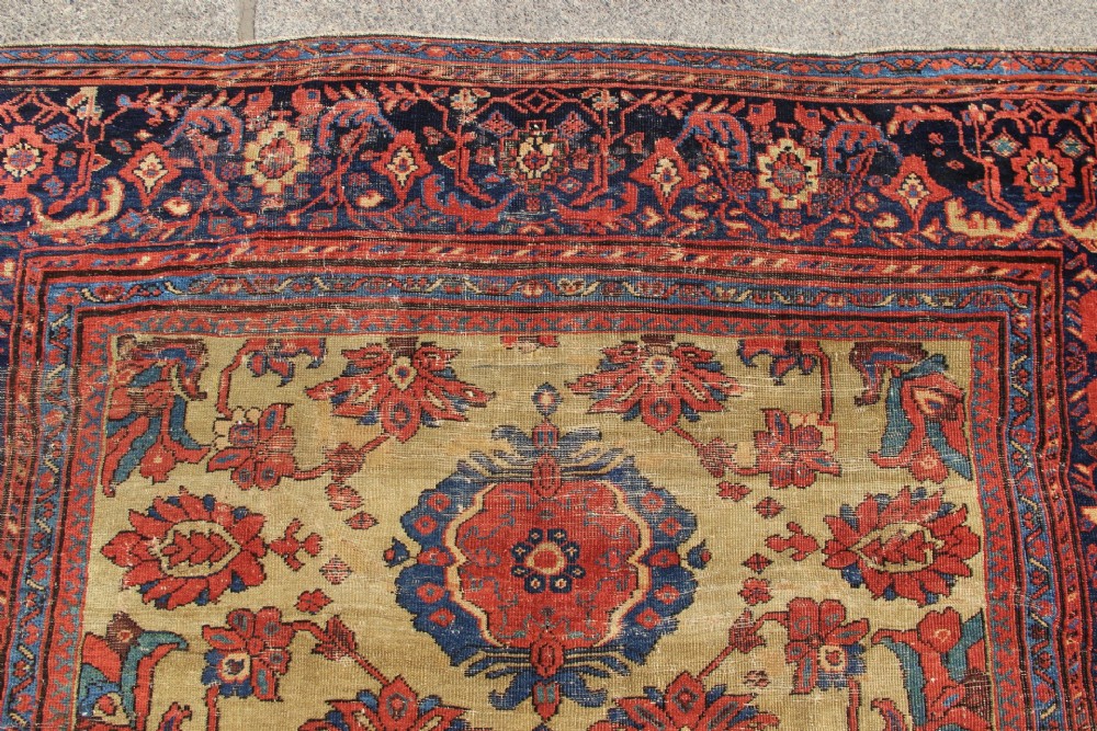 An antique hand-knotted Fereghan Persian carpet featuring a central cream field filled with red and navy floral motifs framed by a wide geometric border. View VIII