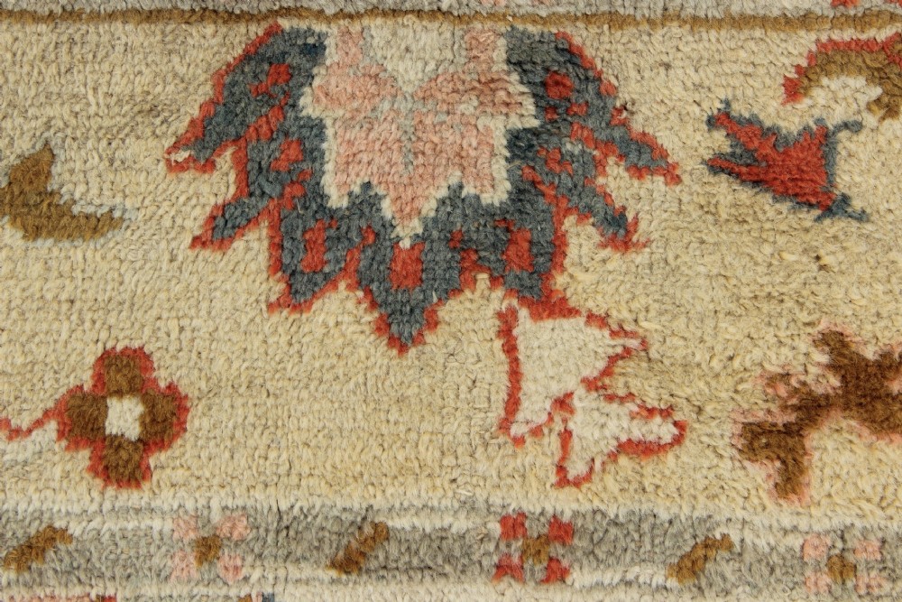 An antique hand-knotted wool carpet featuring a central medallion on a peach-coloured field surrounded by patterned floral borders. View XIII