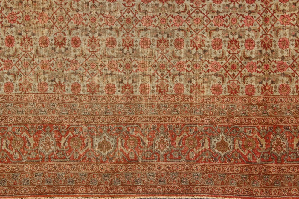 A large rectangular hand-knotted Persian Tabriz wool carpet featuring an all-over repeating geometric and floral pattern in terracotta, rust red, and beige framed by a complex multi-band border. View III