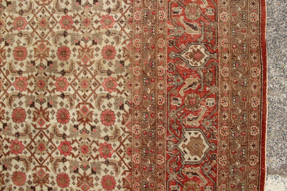 A large rectangular hand-knotted Persian Tabriz wool carpet featuring an all-over repeating geometric and floral pattern in terracotta, rust red, and beige framed by a complex multi-band border. View IV