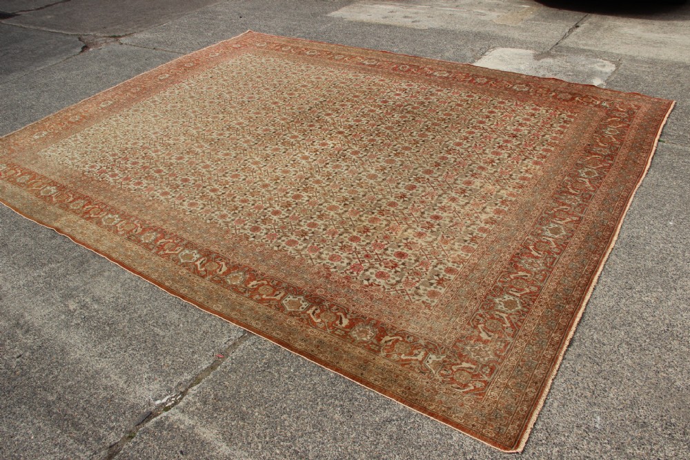 A large rectangular hand-knotted Persian Tabriz wool carpet featuring an all-over repeating geometric and floral pattern in terracotta, rust red, and beige framed by a complex multi-band border. View VIII