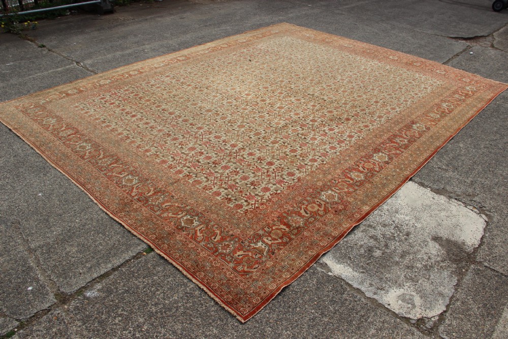 A large rectangular hand-knotted Persian Tabriz wool carpet featuring an all-over repeating geometric and floral pattern in terracotta, rust red, and beige framed by a complex multi-band border. View XIV