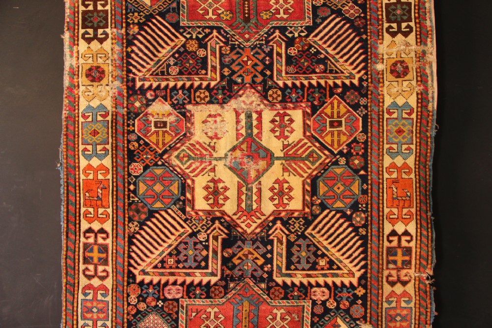 A long hand-knotted antique Caucasian Akstafa wool rug featuring geometric star medallions, stylized bird motifs, and a patterned border on a navy ground. View II