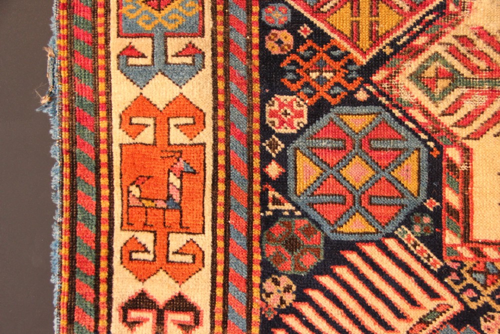 A long hand-knotted antique Caucasian Akstafa wool rug featuring geometric star medallions, stylized bird motifs, and a patterned border on a navy ground. View VI