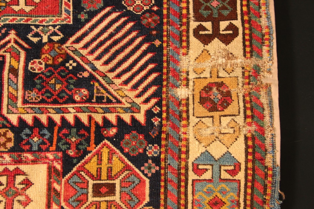 A long hand-knotted antique Caucasian Akstafa wool rug featuring geometric star medallions, stylized bird motifs, and a patterned border on a navy ground. View VII