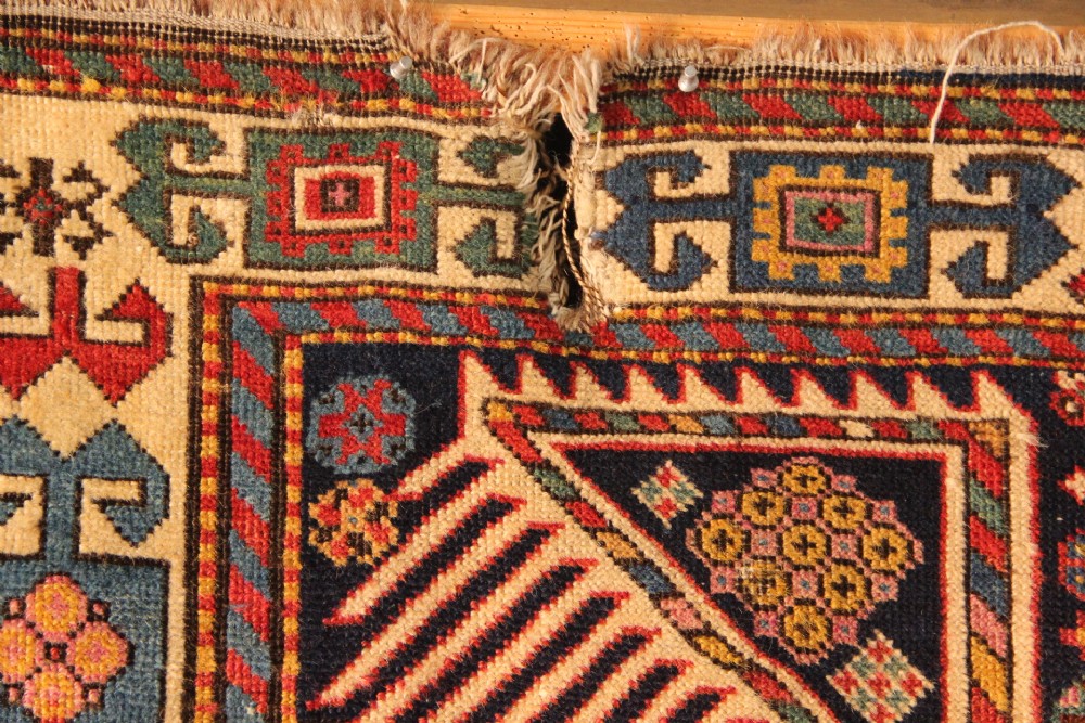 A long hand-knotted antique Caucasian Akstafa wool rug featuring geometric star medallions, stylized bird motifs, and a patterned border on a navy ground. View IX