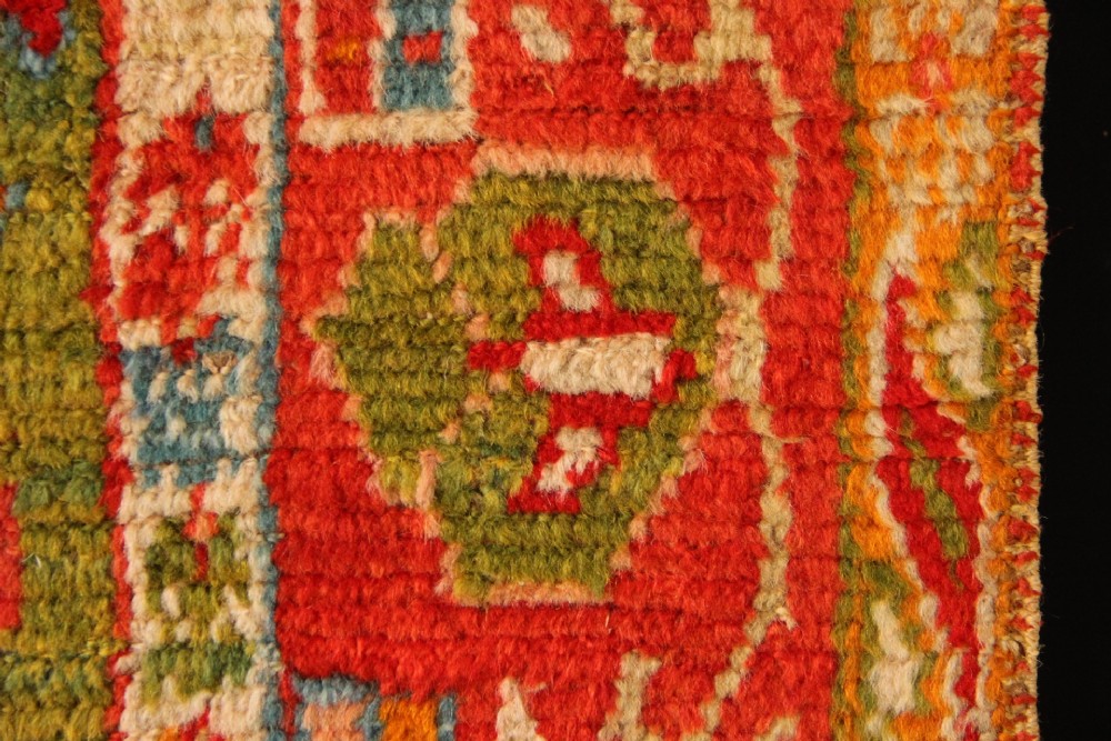 An antique hand-knotted Oushak wool rug featuring an olive green field with soft red, pink, and cream floral medallions surrounded by a terracotta patterned border. View VIII