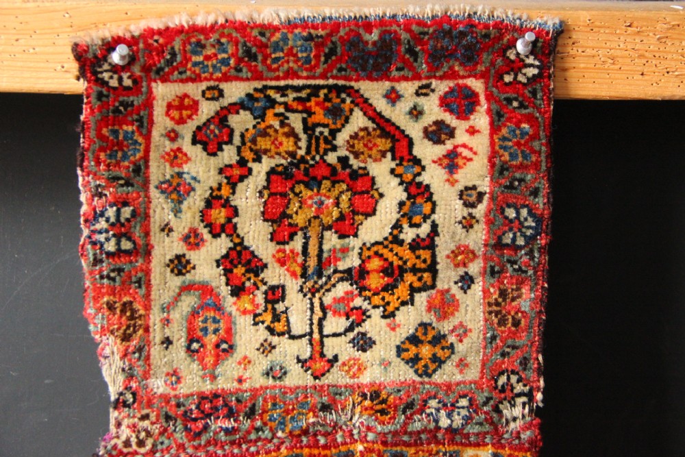 A handwoven antique Qashqai chanteh featuring red, navy blue, and cream wool with geometric diamond lattices and floral medallion patterns. View II