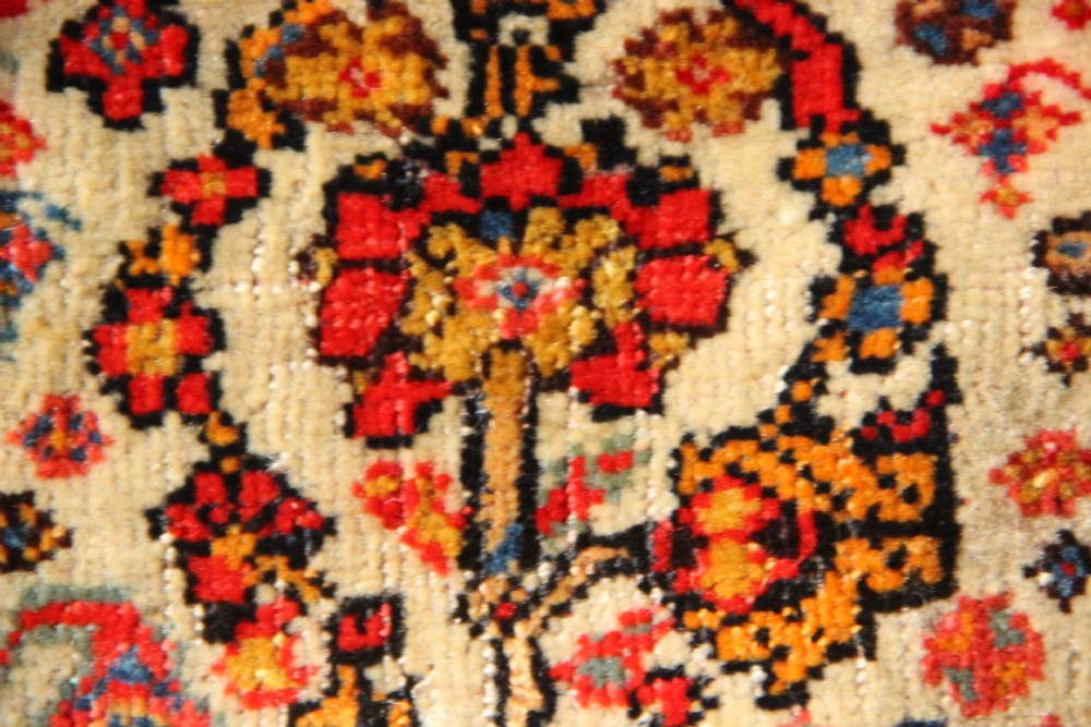 A handwoven antique Qashqai chanteh featuring red, navy blue, and cream wool with geometric diamond lattices and floral medallion patterns. View III