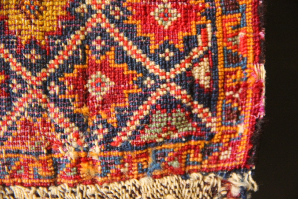 A handwoven antique Qashqai chanteh featuring red, navy blue, and cream wool with geometric diamond lattices and floral medallion patterns. View IX