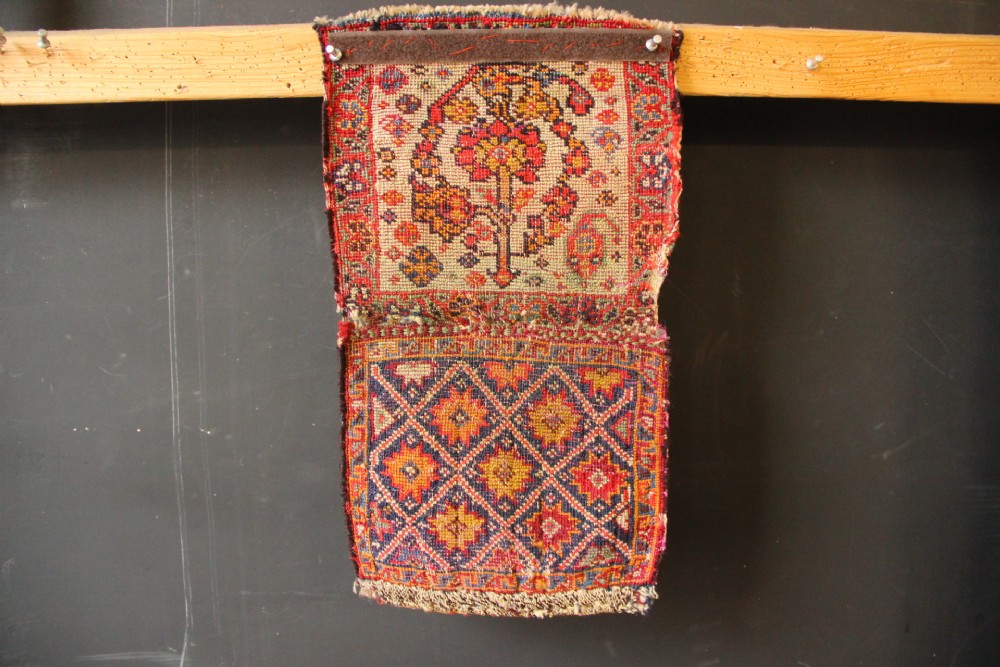 A handwoven antique Qashqai chanteh featuring red, navy blue, and cream wool with geometric diamond lattices and floral medallion patterns. View X
