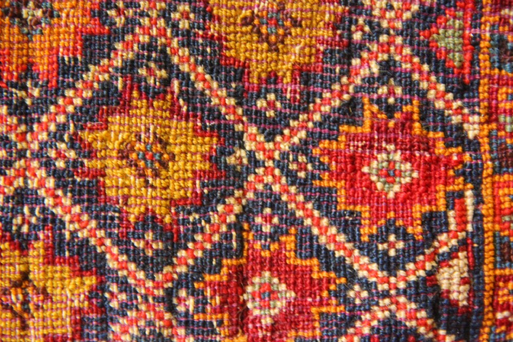 A handwoven antique Qashqai chanteh featuring red, navy blue, and cream wool with geometric diamond lattices and floral medallion patterns. View XI