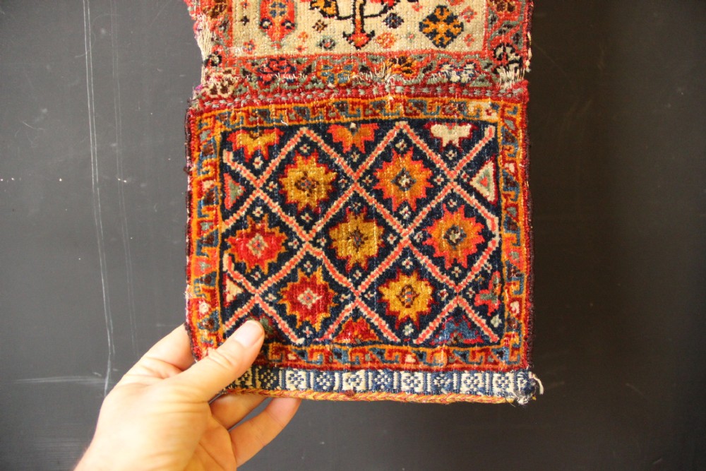 A handwoven antique Qashqai chanteh featuring red, navy blue, and cream wool with geometric diamond lattices and floral medallion patterns. View XII