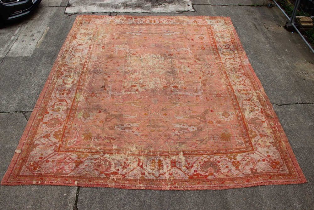 An oversized antique Turkish Oushak wool carpet featuring soft apricot, terracotta, and cream tones with traditional botanical borders and motifs. View VII