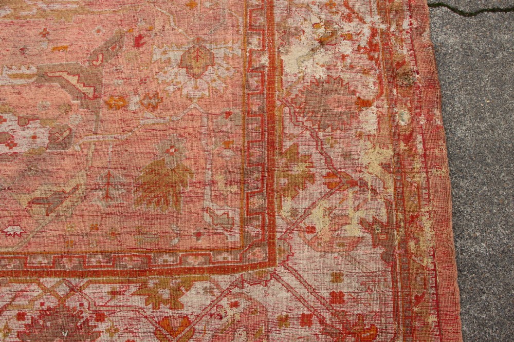 An oversized antique Turkish Oushak wool carpet featuring soft apricot, terracotta, and cream tones with traditional botanical borders and motifs. View IX