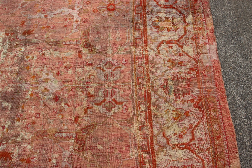 An oversized antique Turkish Oushak wool carpet featuring soft apricot, terracotta, and cream tones with traditional botanical borders and motifs. View X