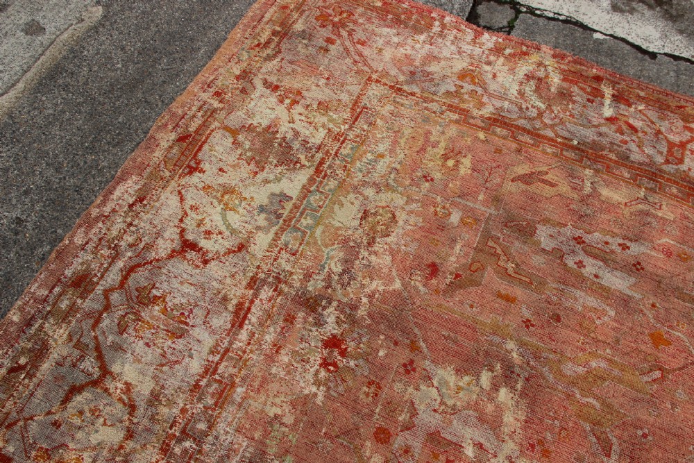 An oversized antique Turkish Oushak wool carpet featuring soft apricot, terracotta, and cream tones with traditional botanical borders and motifs. View XIII