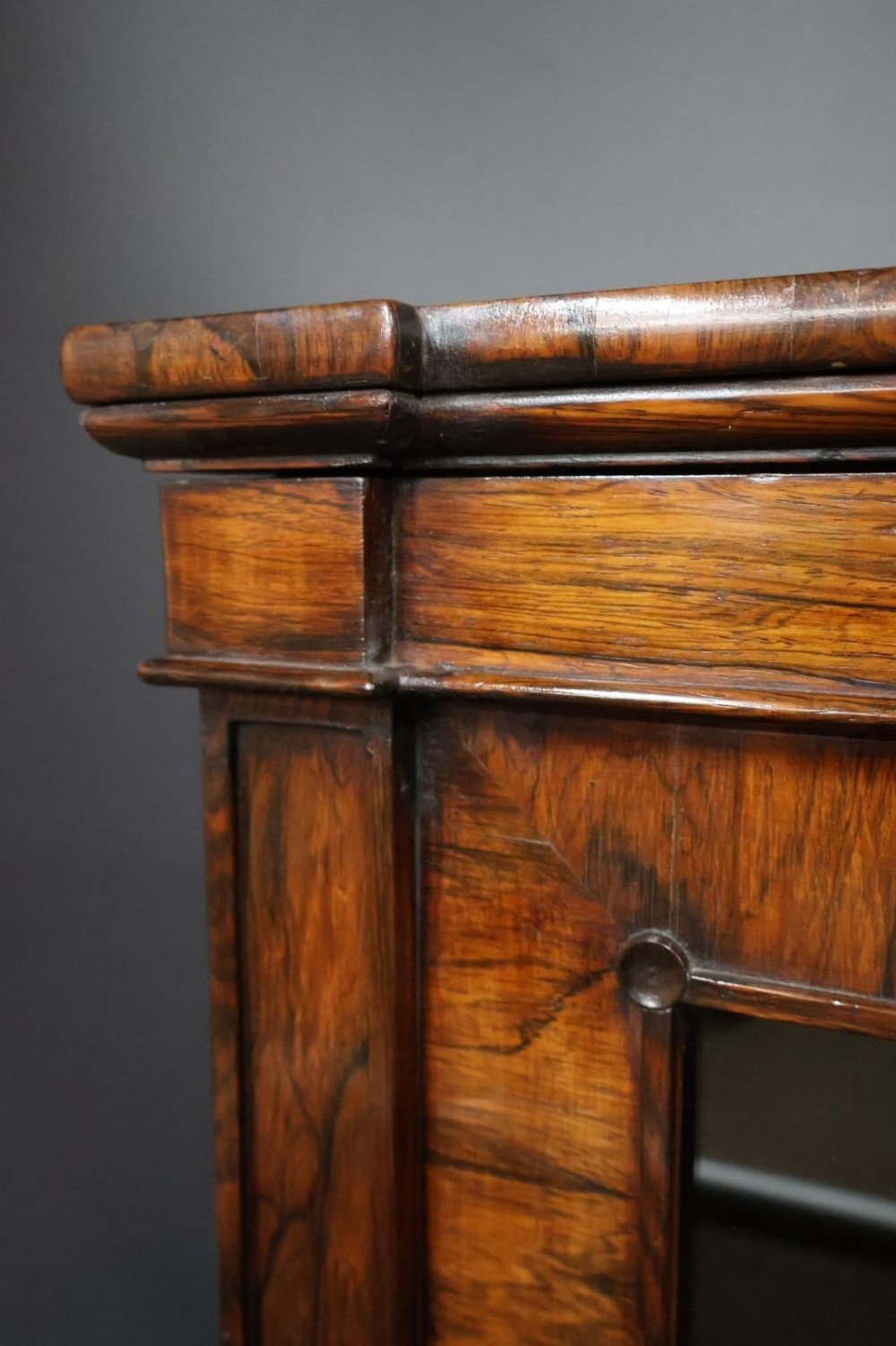 A Regency dark rosewood pier cabinet featuring a single glazed door revealing internal shelves, set on turned bun feet. View VI