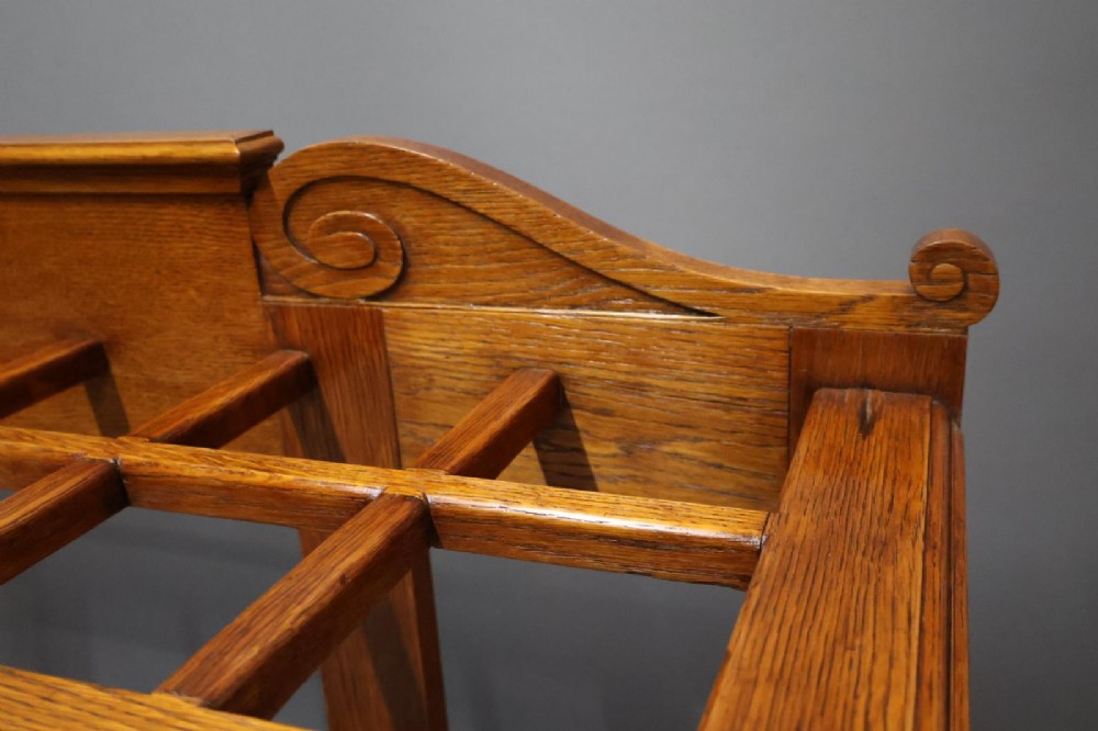 A large Victorian carved oak umbrella and stick stand featuring turned front supports, multiple upper divisions, and a metal drip tray at the base. View IV