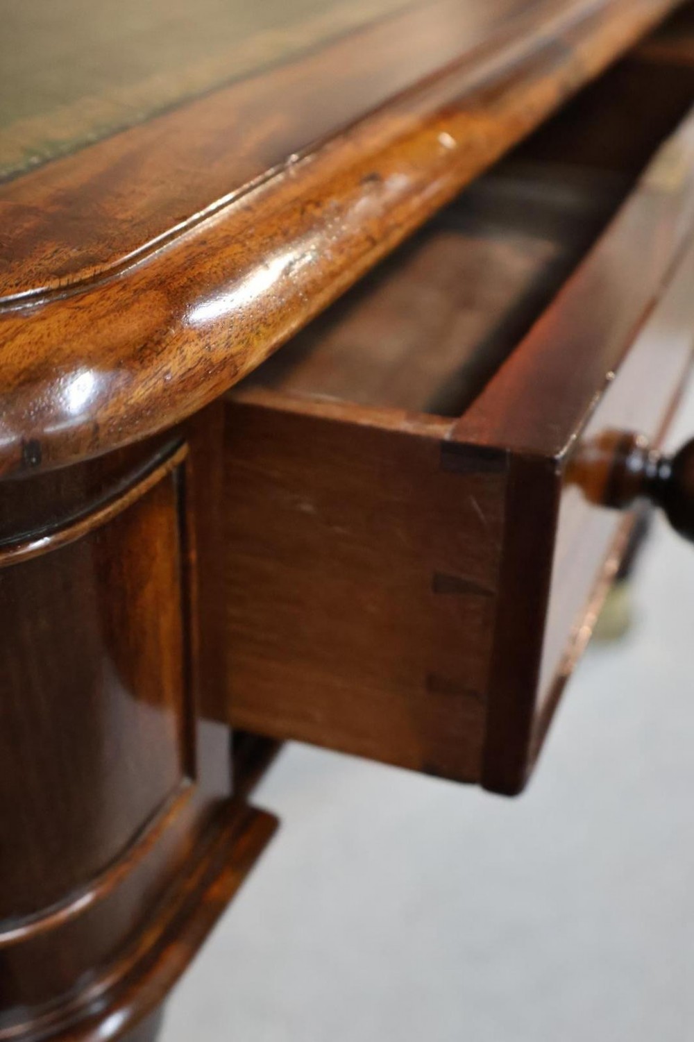 An early nineteenth-century mahogany writing table featuring an inset green leather writing surface, two frieze drawers, and reeded turned legs on brass castors. View VIII