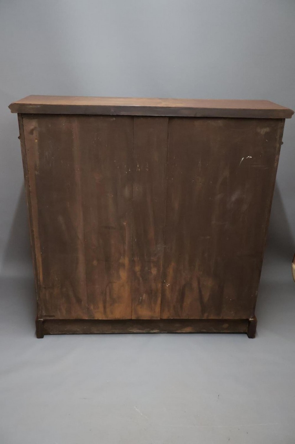 An Edwardian low walnut bookcase featuring two glass-fronted doors, reeded frieze detailing, fluted pilasters, and shelves filled with leather-bound books. View XIII