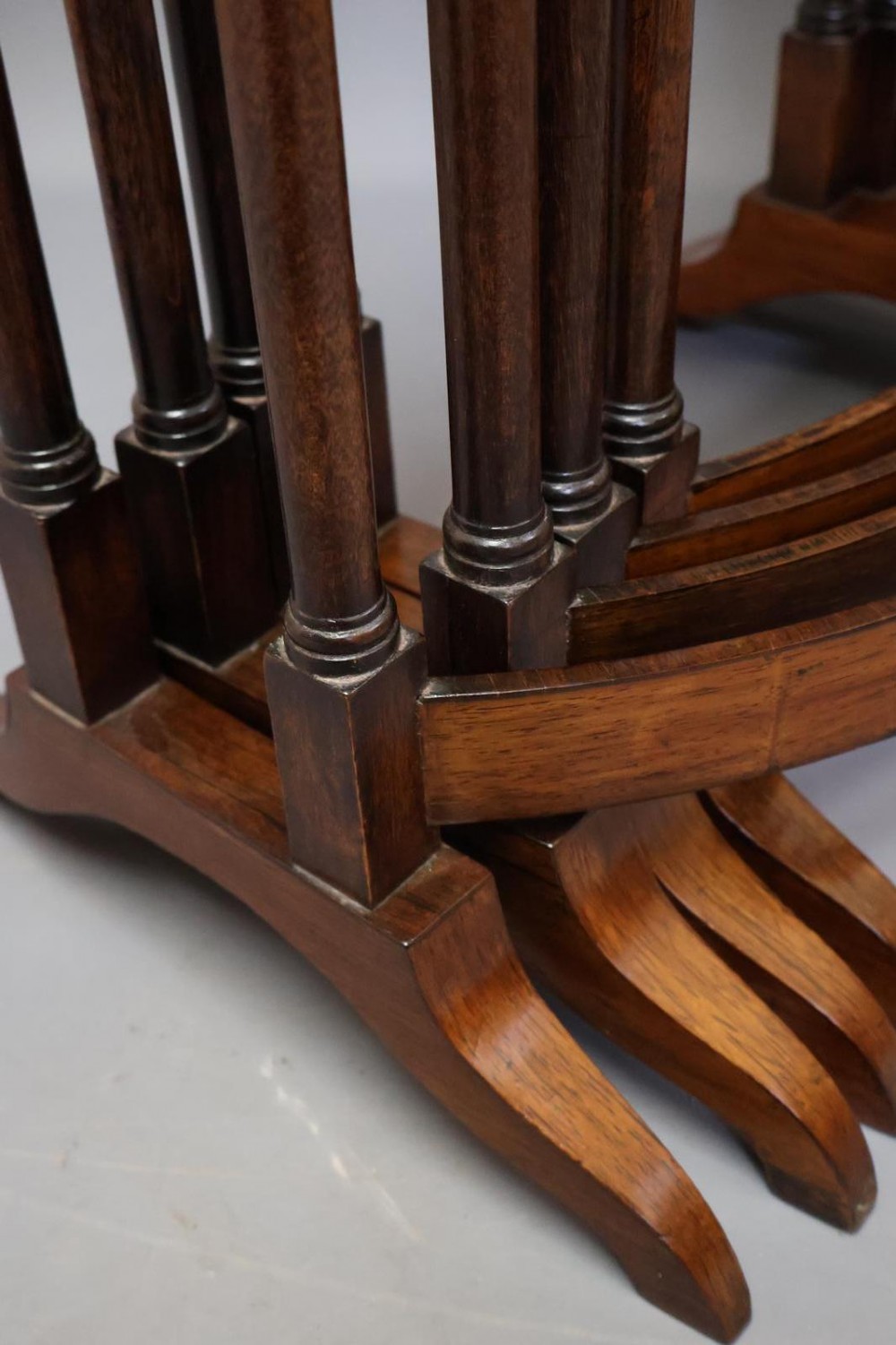 A set of four nested Regency rosewood tables featuring rectangular tops, slender turned spindle legs, and curved lower stretchers. View IX