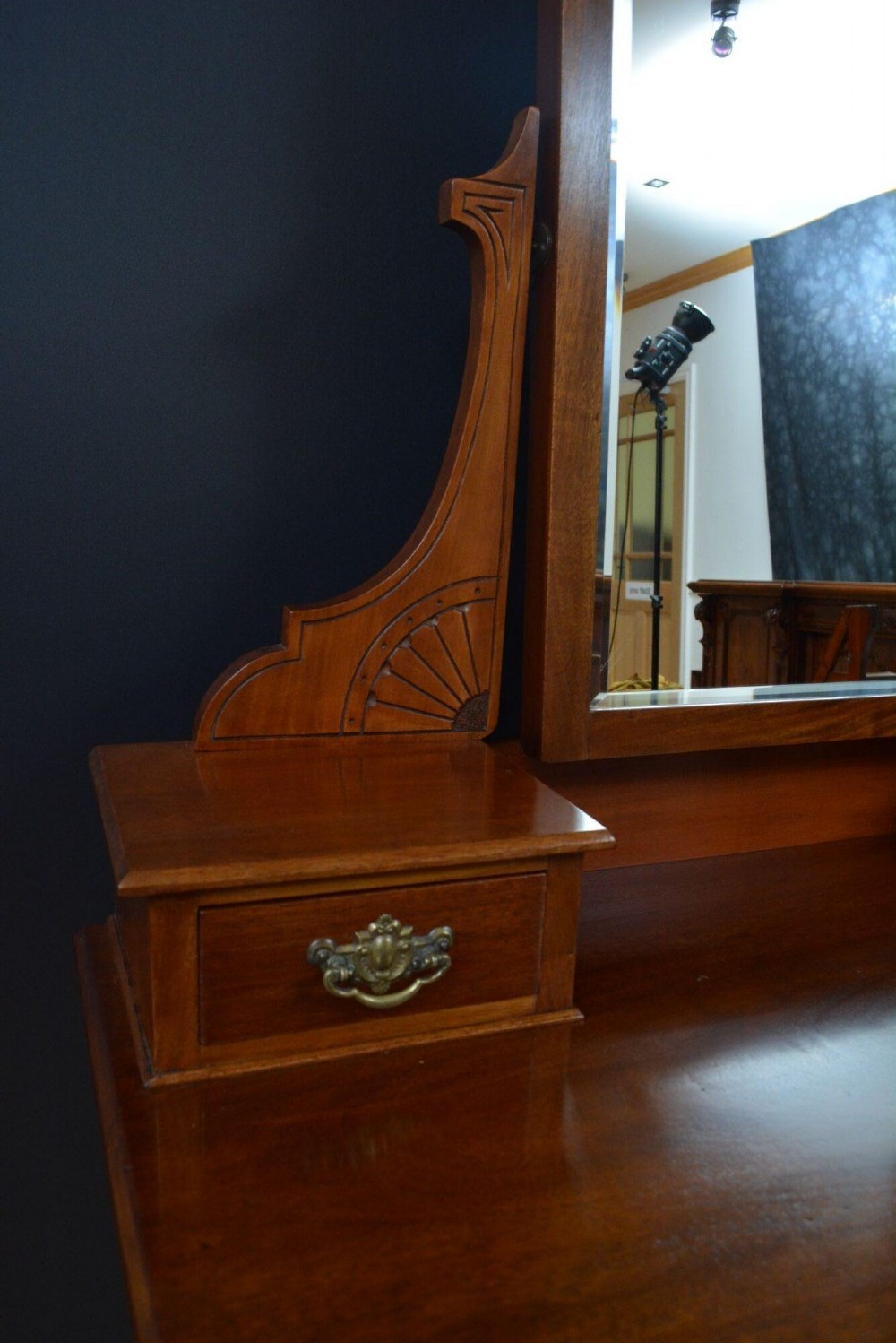 An Edwardian mahogany dressing table featuring a central rectangular mirror flanked by small jewellery drawers, resting on turned legs with brass casters. View IX