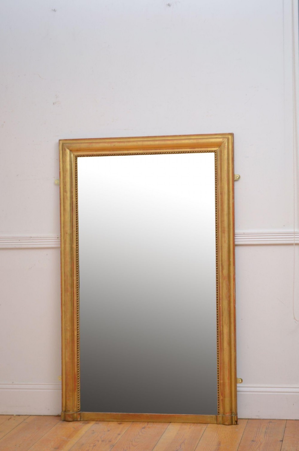 A large rectangular French antique wall mirror featuring a giltwood frame with fine bead moulding around the inner sight edge.
