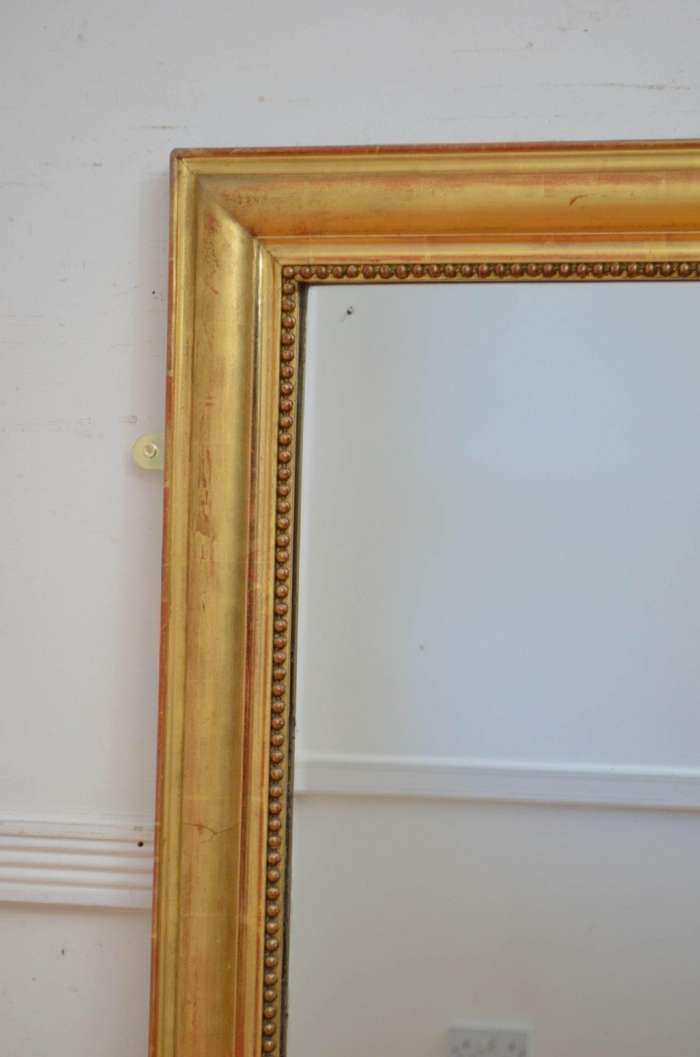 A large rectangular French antique wall mirror featuring a giltwood frame with fine bead moulding around the inner sight edge. View V