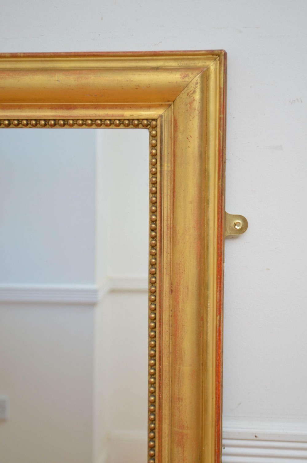 A large rectangular French antique wall mirror featuring a giltwood frame with fine bead moulding around the inner sight edge. View VI