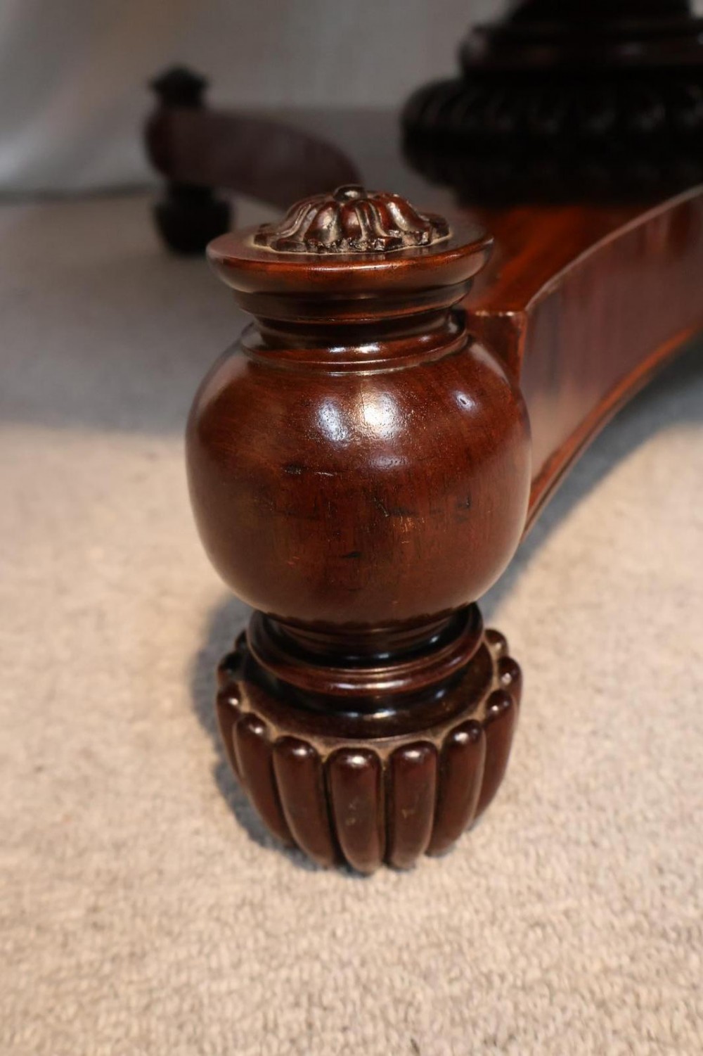 A Regency circular flame mahogany centre table shown in a tilted position on a curved triform base. View XIII
