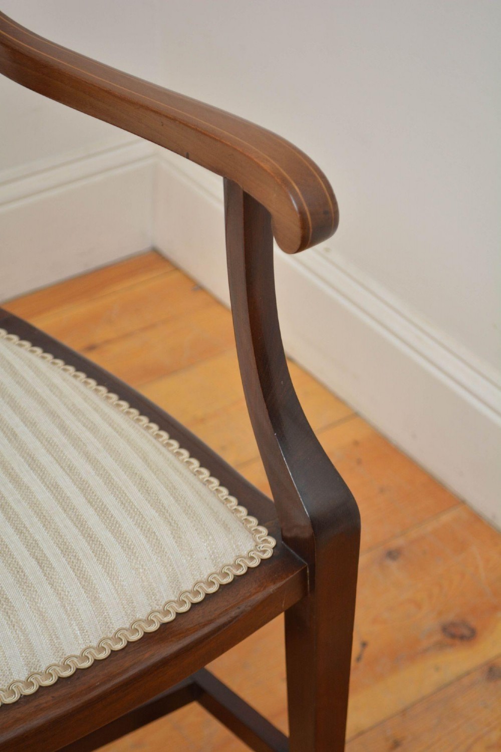 An Art Nouveau mahogany armchair featuring a pierced back splat with inlaid detailing, swept armrests, and a cream striped upholstered seat. View IX