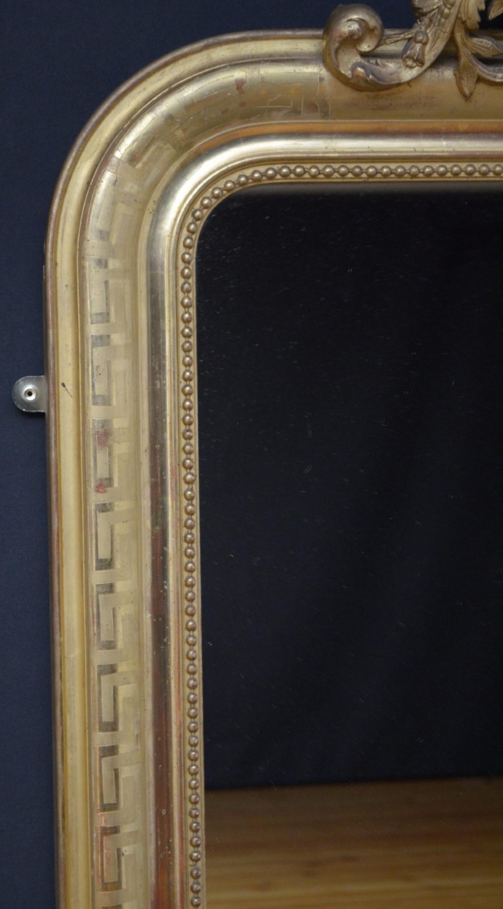 A 19th-century French wall mirror featuring a rectangular frame with rounded top corners, a gold leaf finish, and an ornate carved shell cresting. View VI