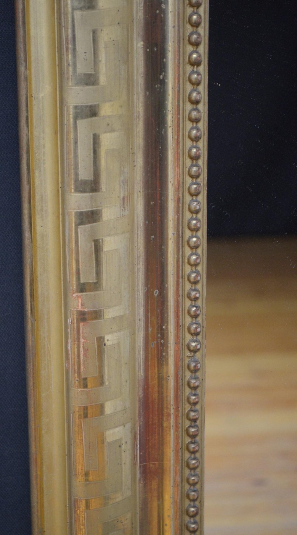 A 19th-century French wall mirror featuring a rectangular frame with rounded top corners, a gold leaf finish, and an ornate carved shell cresting. View VII