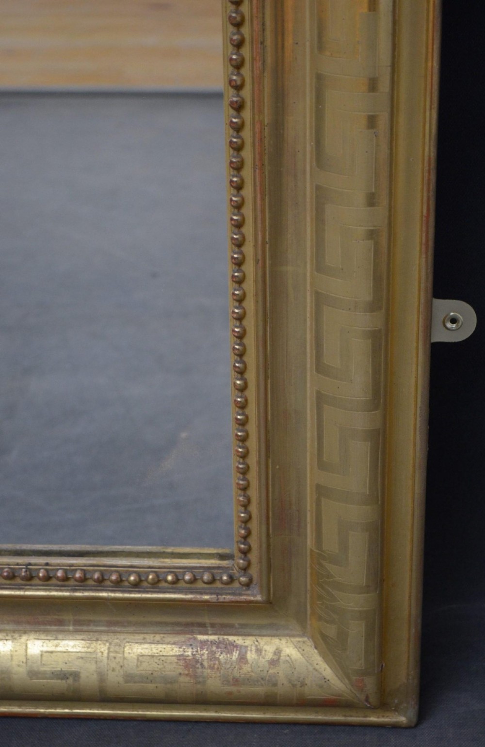 A 19th-century French wall mirror featuring a rectangular frame with rounded top corners, a gold leaf finish, and an ornate carved shell cresting. View XII