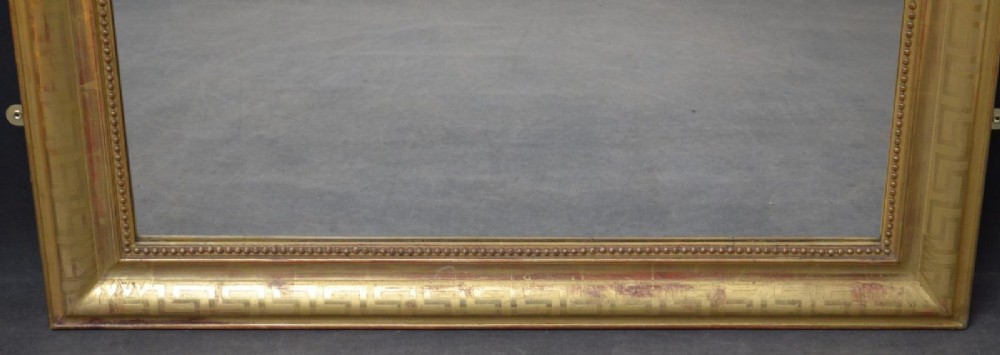 A 19th-century French wall mirror featuring a rectangular frame with rounded top corners, a gold leaf finish, and an ornate carved shell cresting. View XIII